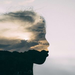 a silhouette of a person with a cloudy sky in the background