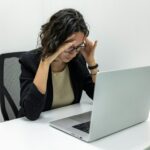 a woman sitting in front of a laptop computer