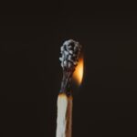 A lit matchstick with a black background